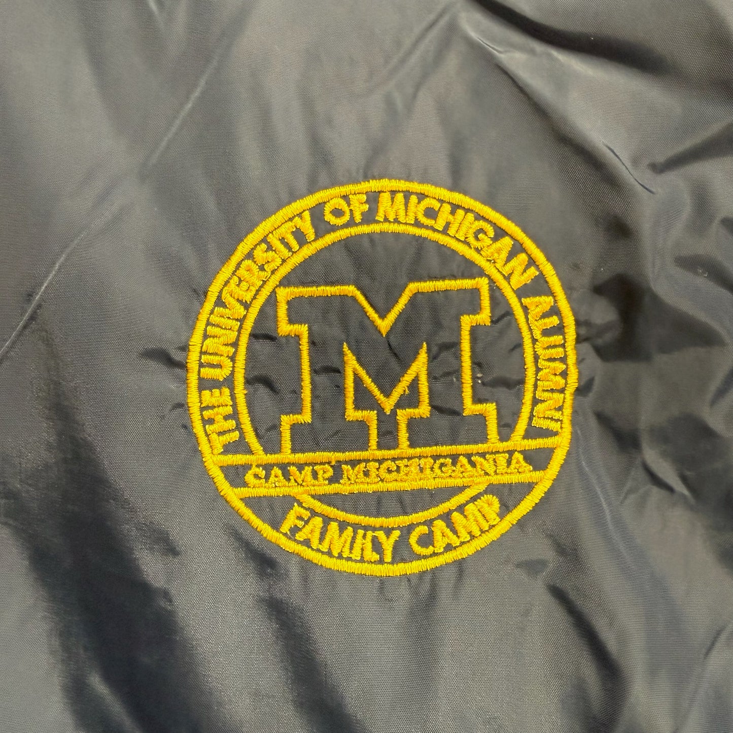 Gray jacket with a yellow embroidered patch on a gray background