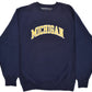 University of Michigan navy blue crewneck sweatshirt featuring the word 'MICHIGAN' embroidered in yellow letters with a white outline across the chest.
