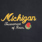 Close-up of University of Michigan navy blue crewneck sweatshirt embroidered text reading 'Michigan Tournament of Roses' in yellow and white, plus a small red rose graphic.