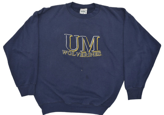 A University of Michigan navy blue crewneck sweatshirt featuring 'UM WOLVERINES' embroidered in gold and white on the chest.