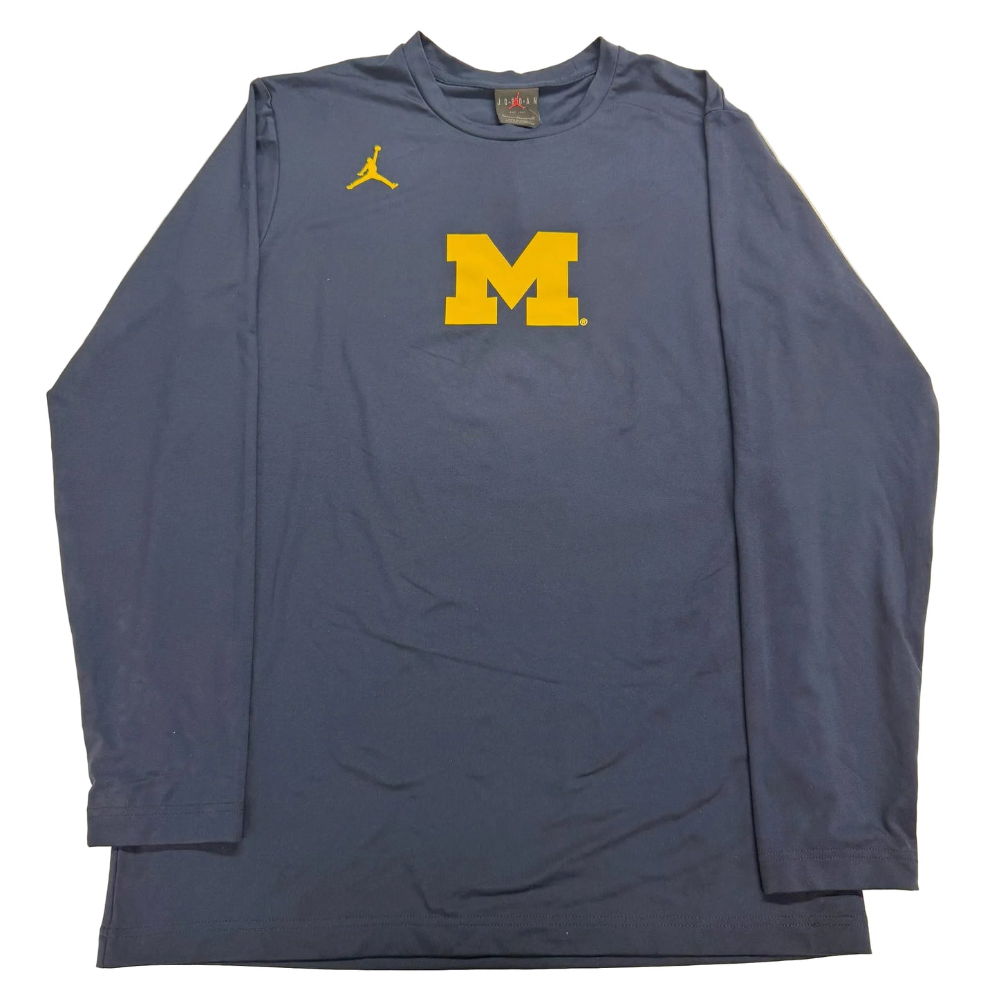 Blue long-sleeve shirt with yellow 'M' logo on a beige background