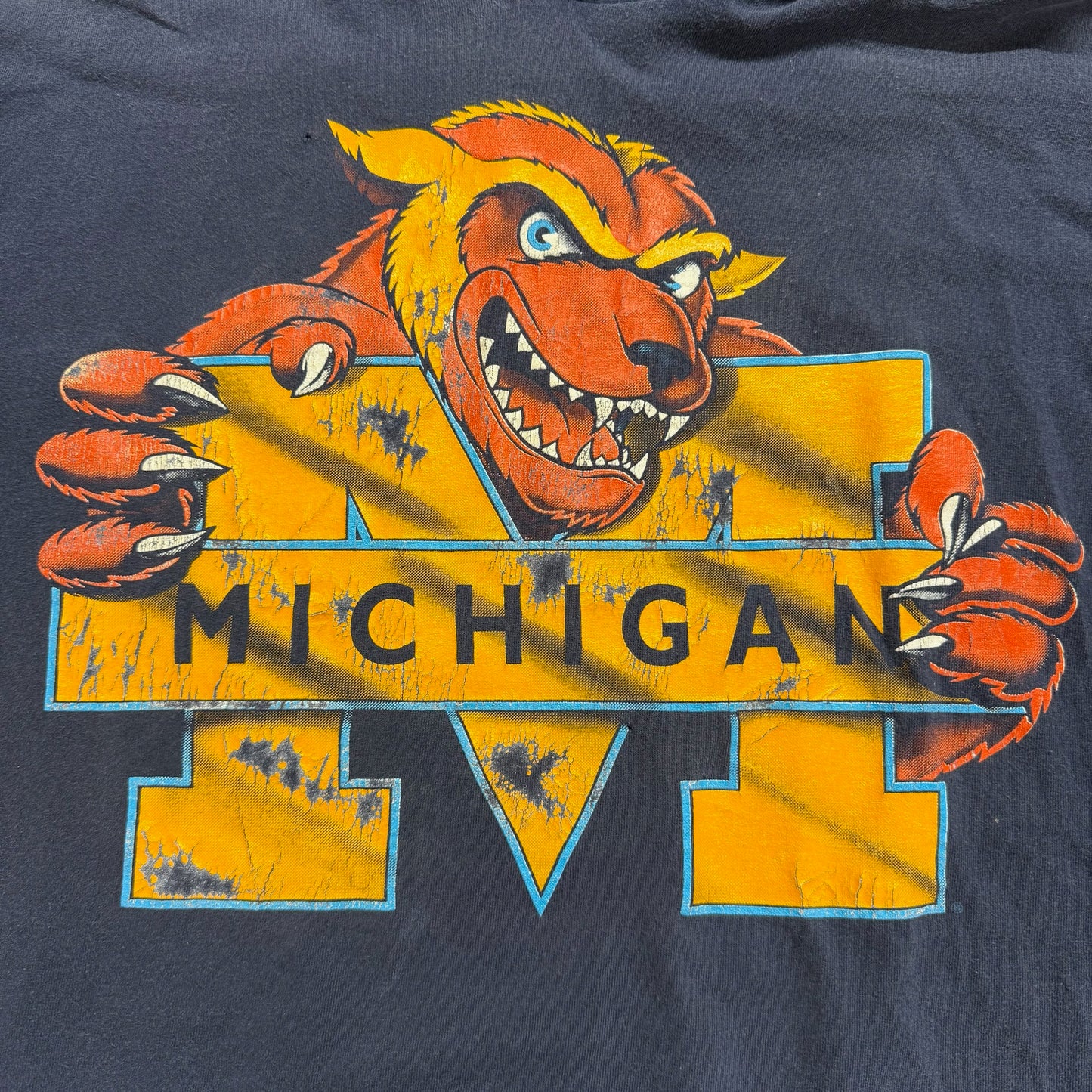 Vintage Michigan Wolverines logo on a dark blue background