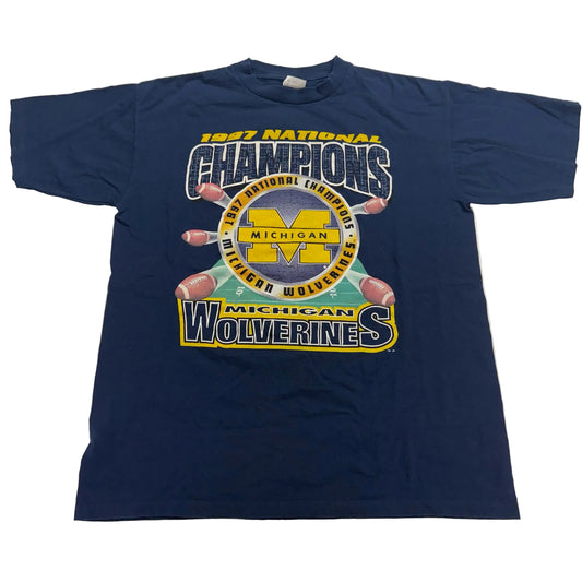 Navy blue t-shirt with '1987 National Champions Michigan Wolverines' graphic on a white background