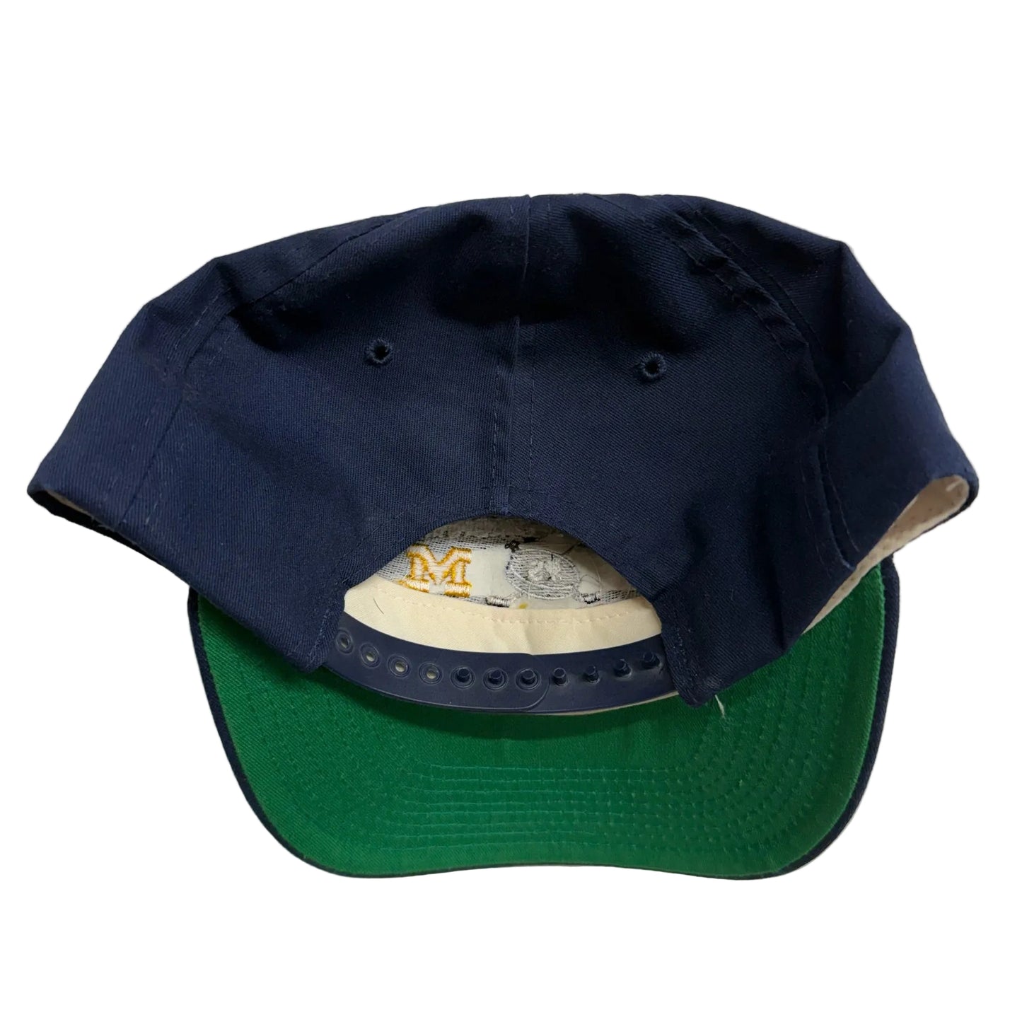 Navy and green baseball cap on a light gray background