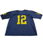 Blue sports jersey with yellow number 12 on a white surface