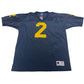 Blue sports jersey with yellow number 2 on a white surface