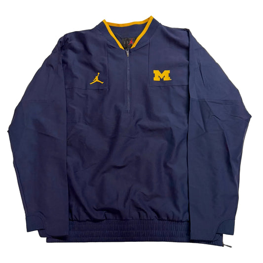 Navy blue jacket with yellow accents and logos on a light gray background