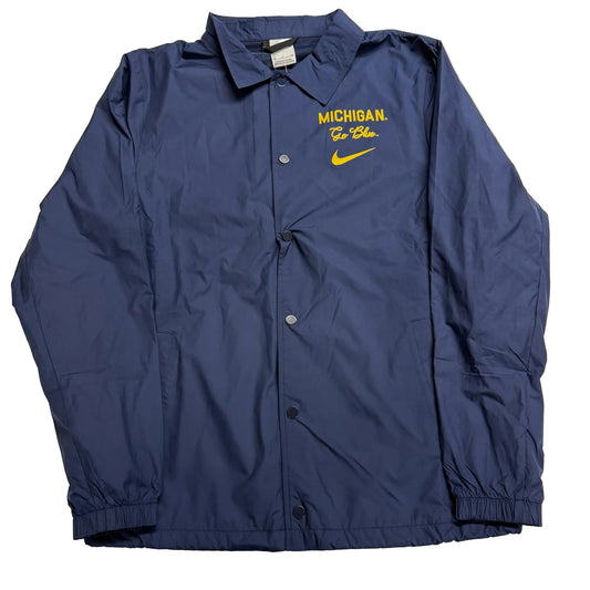 Blue jacket with 'Michigan' and Nike logo on a beige background