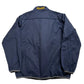 Blue jacket with 'Michigan' text on the back, laid flat on a light-colored surface.