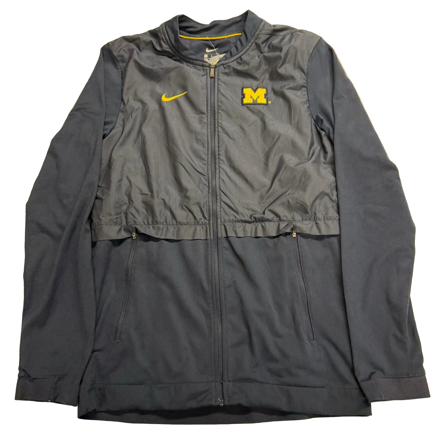 Gray jacket with Nike and Michigan logos on a beige background