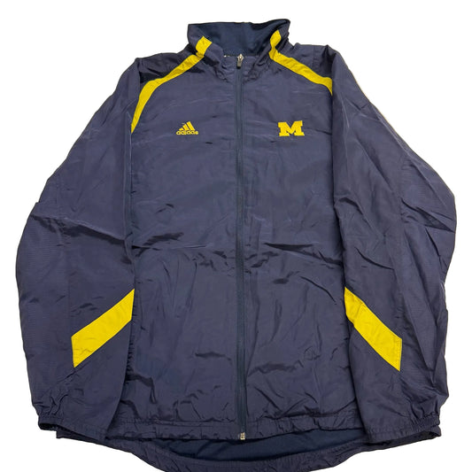 Navy jacket with yellow accents and Adidas logo on a beige background