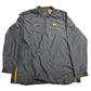 Gray jacket with Nike logo and Michigan Wolverines emblem on a beige background