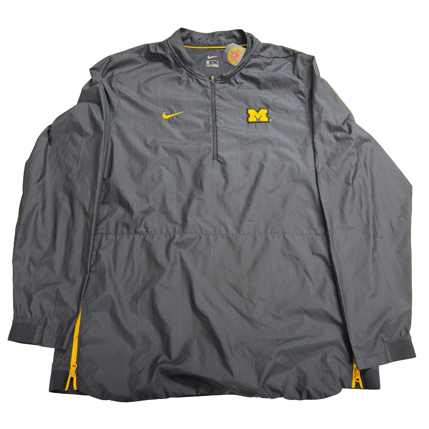 Gray jacket with Nike logo and Michigan Wolverines emblem on a beige background