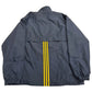 Navy blue jacket with yellow stripes on a beige surface